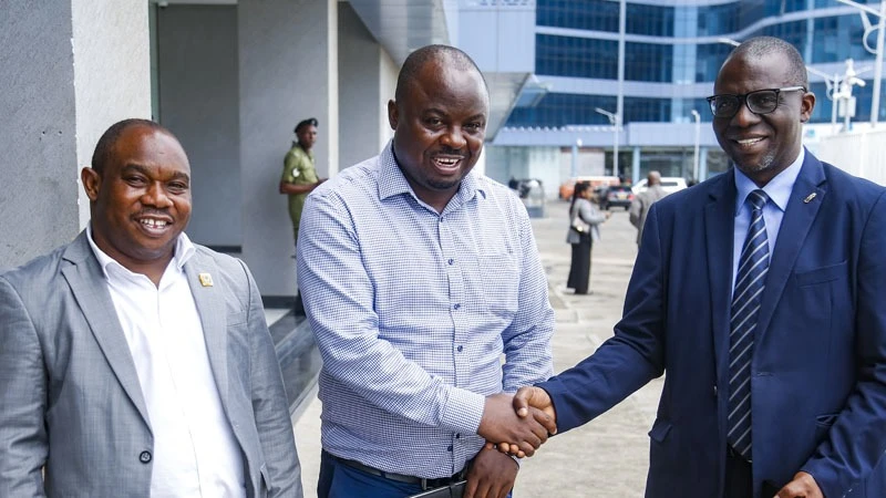 Parliamentary Public Investment Committee chairman Deus Sangu (C) exchanges greetings with Public Service Social Security Fund (PSSSF) director general Abdul-Razak Badru 