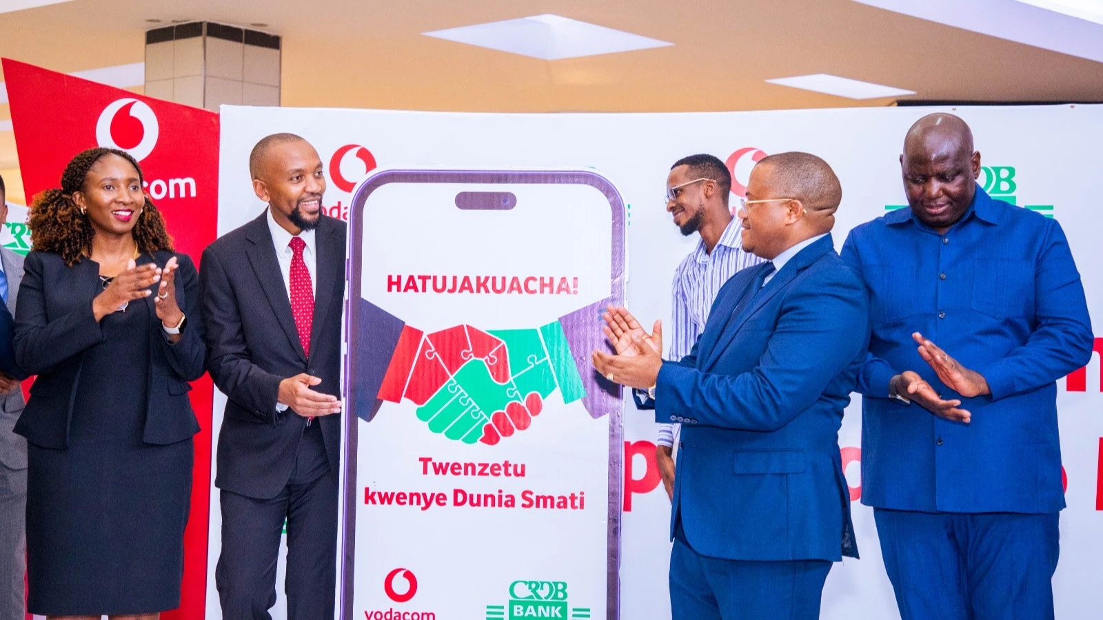  The Managing Director of Vodacom, Philip Besiimire (left), and Managing Director of CRDB Bank, Abdulmajid Nsekela, applauding immediately after launching.