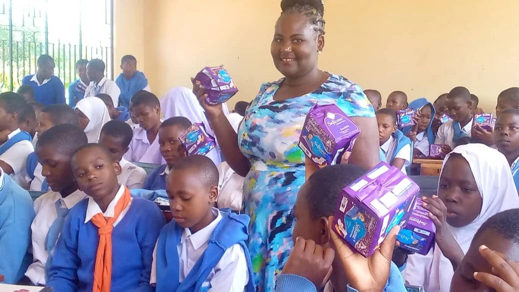 Mwanahabari Grace Mbise akiwa na wanafunzi wa shule ya Sekondari Kayenze baada ya kuwakabidhi msaada wa taulo za kike.