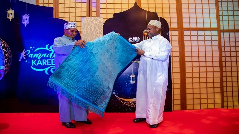 Former President Jakaya Kikwete receives a special gift from NBC Bank managing director, Theobald Sabi (R), during an iftar event organized by the bank for its customers in Dar es Salaam on Saturday.