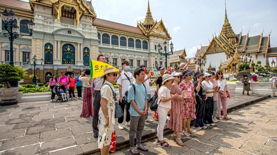 Chinese tourists pose for a group photo at Ancient Siam in Samut Prakan, Thailand, on Monday. 