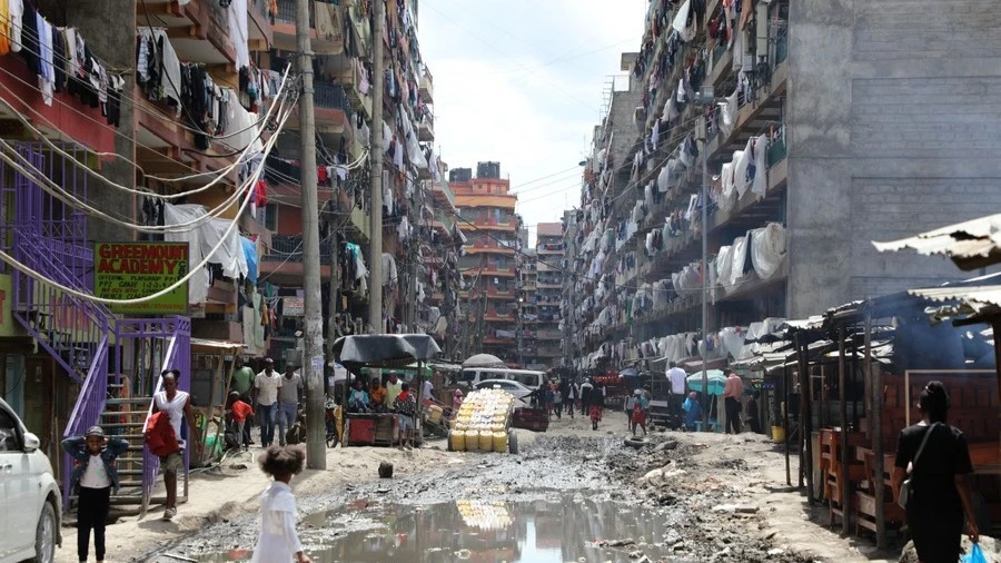 Locals go about their businesses in a polluted street of Pipeline estate in Nairobi.

