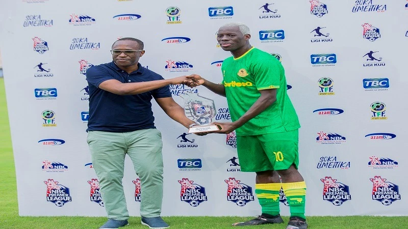 NBC Bank's Acting Managing Director, Elvis Ndunguru (L), is pictured presenting an award to Yanga's midfielder Stephane Aziz Ki, who was announced as the Best Player of the NBC Premier League for March.