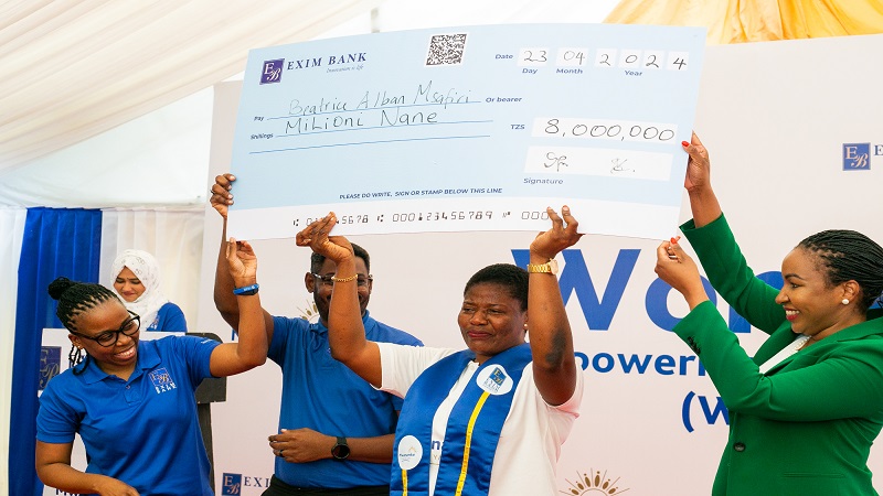Entrepreneur Beatrice Alban Msafiri (2nd R) displays her gift of dummy cheque worth 8m/- after emerging first winner in the entrepreneurship and empowerment training for women entrepreneurs under the Exim Bank's Women Empowerment Programme (WEP).