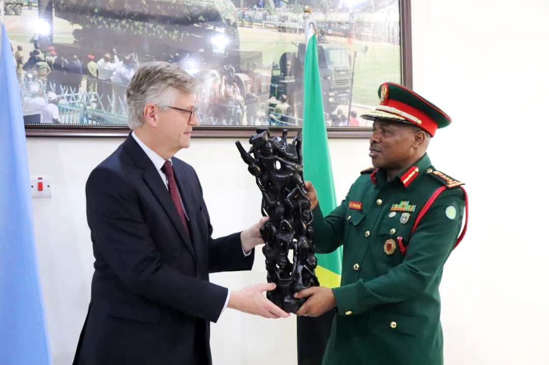 Jean- Pierre Lacroix,o the United Nations Under - Secretary General for peace operations, receives a gift of wood sculpture from the Chief of Defence Forces General Jacob Mkunda shortly after  holding talks in Dar es Salaam yesterday. 