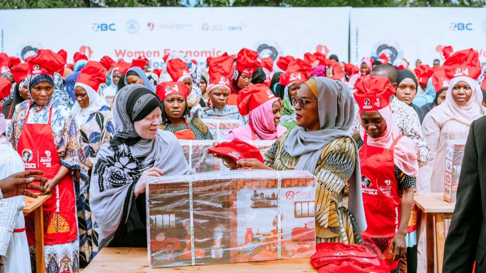 Zanzibar First Lady Mariam Mwinyi hands over a gas stove to one of Women food vendors who are commonly referred as Mama Ntilie Sauda Khamis during an economic inclusion programme called Mwanamke Shujaa which is a partnership between Coca-Cola Kwanza.