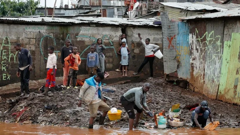 Kenyans wash belongings recovered from their flooded house after the Nairobi River burst its banks within the Mathare Valley settlement in Nairobi.