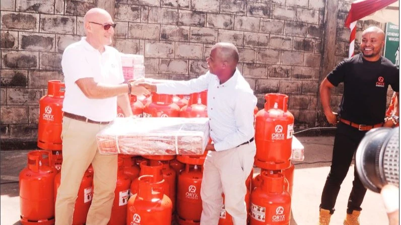 Oryx Gas Tanzania managing director Benoit Araman (L) presents a gas cooker and a 15-kg gas cylinder to journalist Chalila Kibuda shortly after having an audience with several media practitioners at the firm’s depot in Dar es Salaam’s Kigamboni suburb.