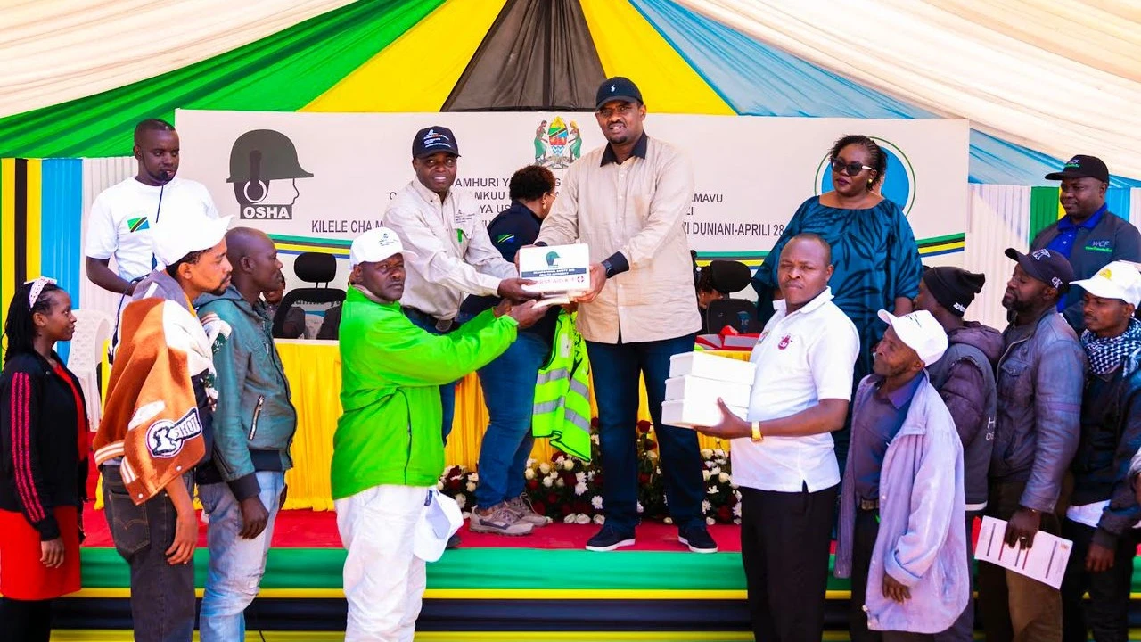 Minister of State in the Prime Minister's Office (Labour, Youth, Employment and People with Disabilities), Deogratius Ndejembi (right) with GGML's Senior Manager for Health, Safety and Environment, Dr. Kiva Mvungi (left) providing protective gear.