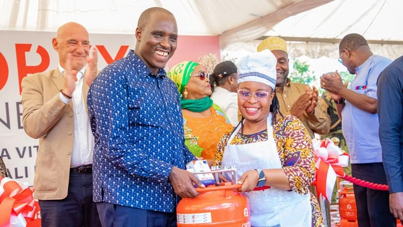 Deputy Prime Minister and minister for Energy Dr Doto Biteko (L) hands over filled Liquefied Petroleum Gas (LPG) cylinder and burner to a woman, as part of the campaign to increasing accesses to clean cooking energy in Tanzania. 