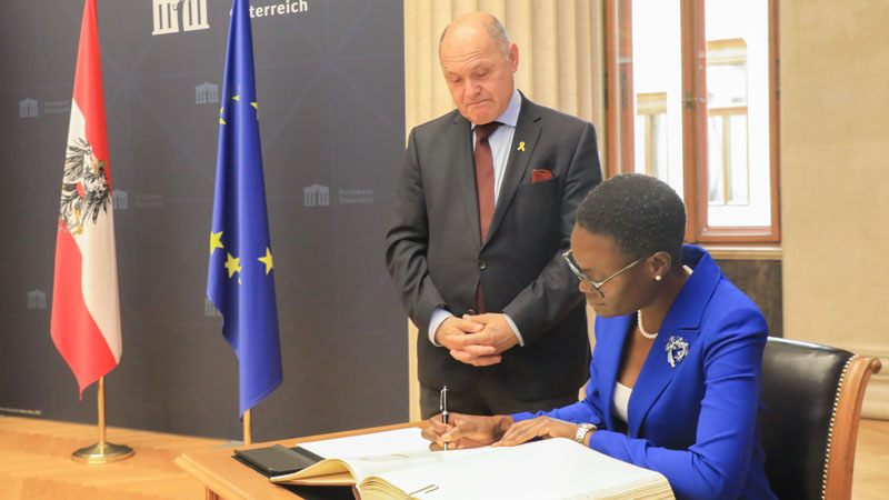 Dr Tulia Ackson, the Inter-Parliamentary Union (IPU) president and Speaker of the National Assembly, signs a record book at the Parliament of Austria in Vienna yesterday. Left is the Speaker of the Austrian Parliament, Wolfgang Sokotka. 