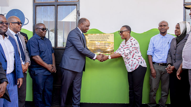 Manyara regional commissioner Queen Sendiga (3rd R) commending CRDB Bank procurement director Pendason Philemon (4th L) in handing over classrooms and teachers’ office at Muungano primary school,  Babati.