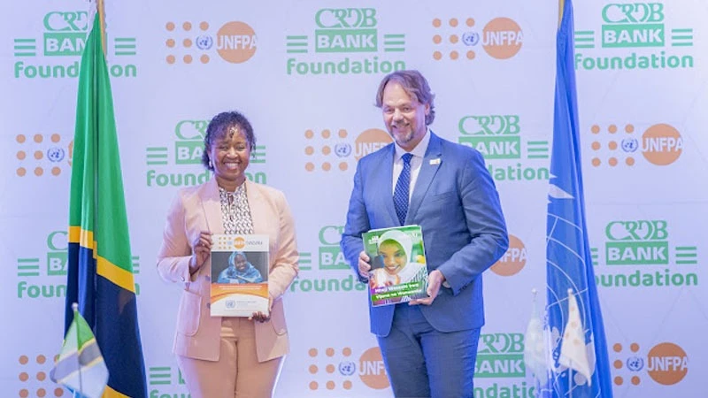 Tully Mwambapa, (Left) CRDB Bank Foundation. managing director Mark Screiner,(Right) United Nations Population Fund resident representative pictured as they showcased 800m/- worth empowerment programe agreements expected to benefit Tanzanian youth.