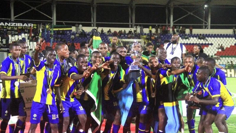 Tanzania U-15 boys’ soccer team players celebrate with their trophy after winning the African Schools Football Championship final match against Guinea at the New Amaan Complex in Zanzibar on Friday. Tanzania won 1-0.