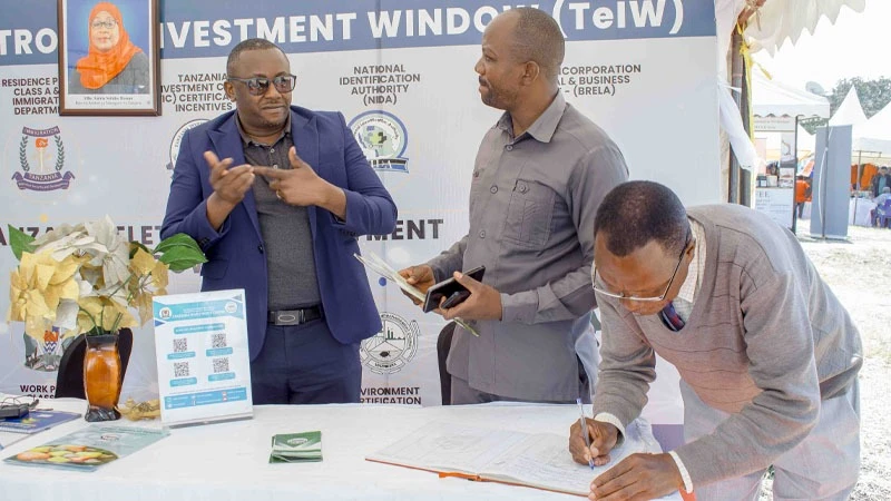 TIC's Southern Highlands Manager, Deusdedit Hokororo (L) edifies visitors at the Mbeya trade fair pavilion