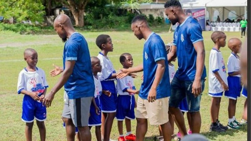 Some players from Simba SC, Mzamiru Yassin, Ladaki Chasambi, and goalkeeper Hussein Abel, greeting some of the children who participated in the children's sports clinic aimed at nurturing young talents.