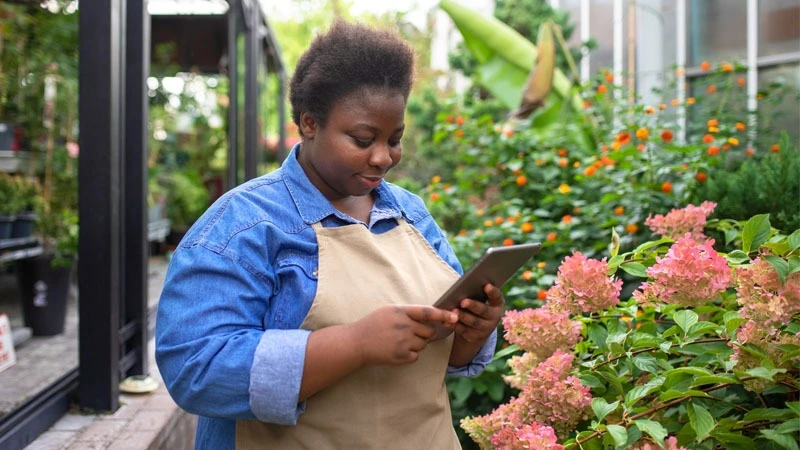 Staying connected on the go: A young woman manages her finances using mobile money as she navigates the bustling city streets.