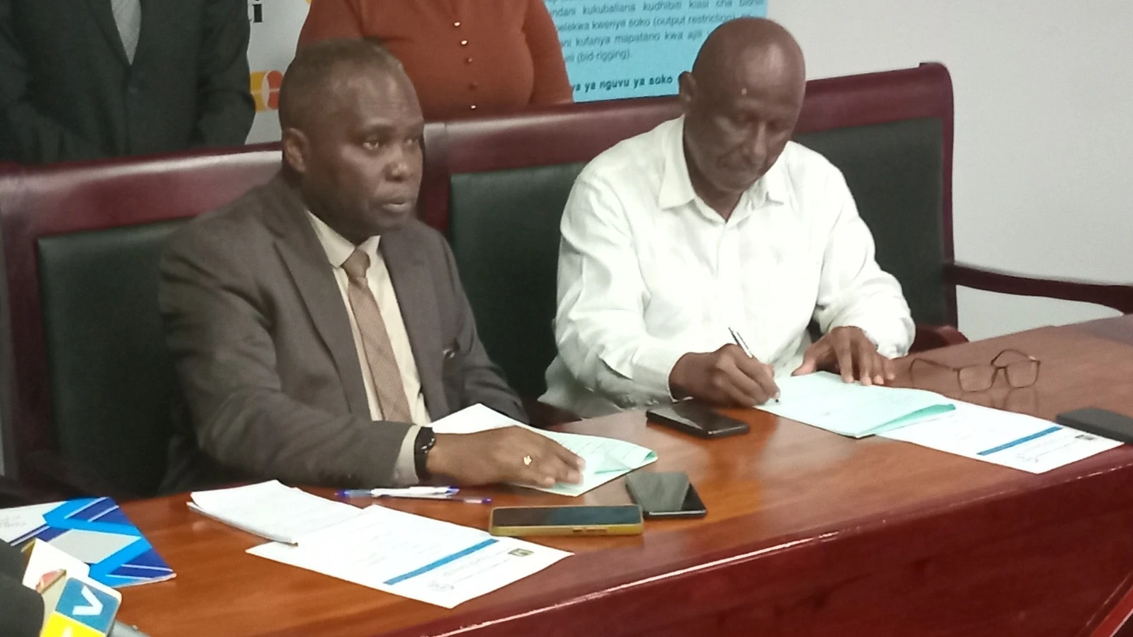 Leodegar Tenga (right), the Confederation of Tanzania Industries executive director and William Erio, the Fair Competition Commission director general, sign a cooperation agreement in Dar es Salaam yesterday. 