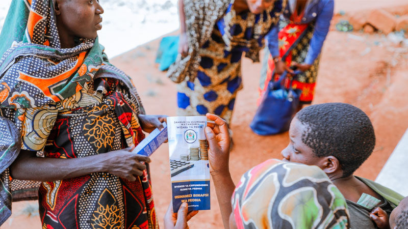 Kigoma Urban residents study leaflets during financial literacy training yesterday organised by the Treasury, instructed on ills of borrowing without clear goals, effects of borrowing from unregistered lenders