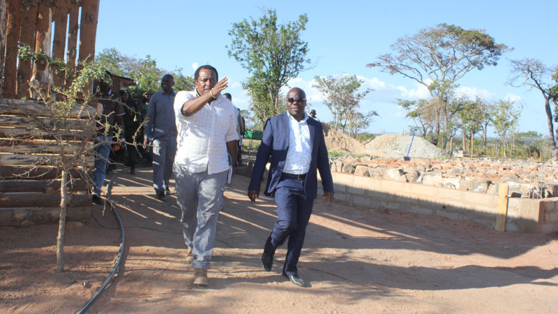 An official with a firm associated with the envisaged implementation of three projects in Mbarali District, including the construction of an airport and a tourism college, briefs Mbeya regional commissioner Juma Homera (R). 