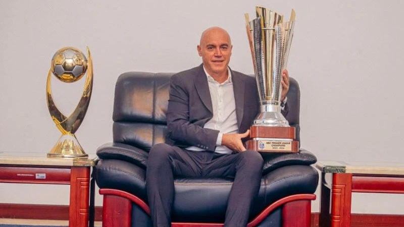 Young Africans head coach Miguel Gamondi with Premier League and Confederation Cup trophies