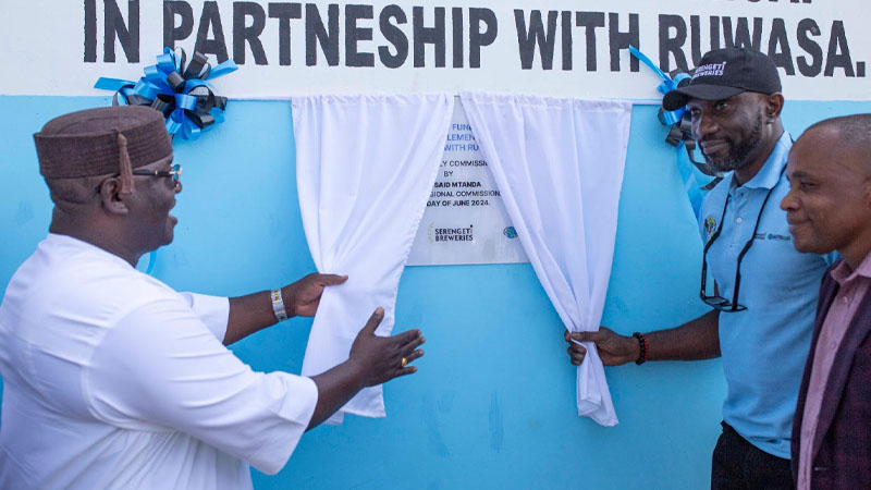 Mwanza Regional Commissioner Said Mtanda (L) and the Serengeti Breweries Managing Director Obinna Anyalebechi unveiling a plaque to mark the official commissioning of a new water supply project in Kabila village in Magu District Mwanza region yesterday