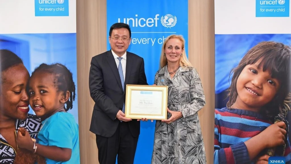 Kitty van der Heijden, deputy executive director of the United Nations Children's Fund (UNICEF), presents President of Xinhua News Agency Fu Hua with a certificate of appreciation to recognize his support and contribution to UN children's initiatives..