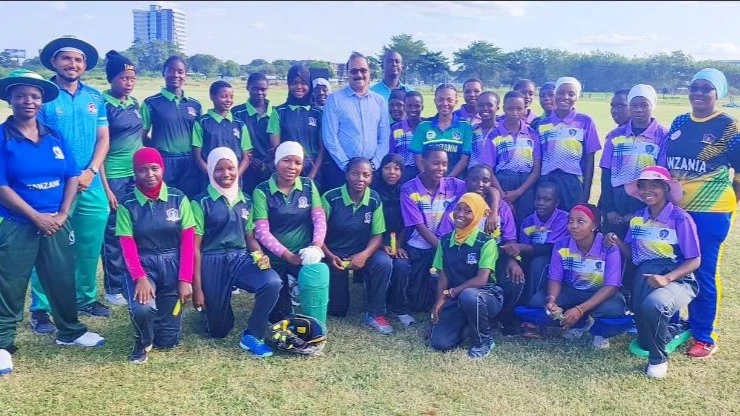 Tanzania Cricket Association (TCA) Chairman Balakrishna Sreekumar (in light blue shirt) poses for a photo with cricketers making the national U-19 women's squad when he visited the latter at a training session at the University of Dar es Salaam (UDSM) .