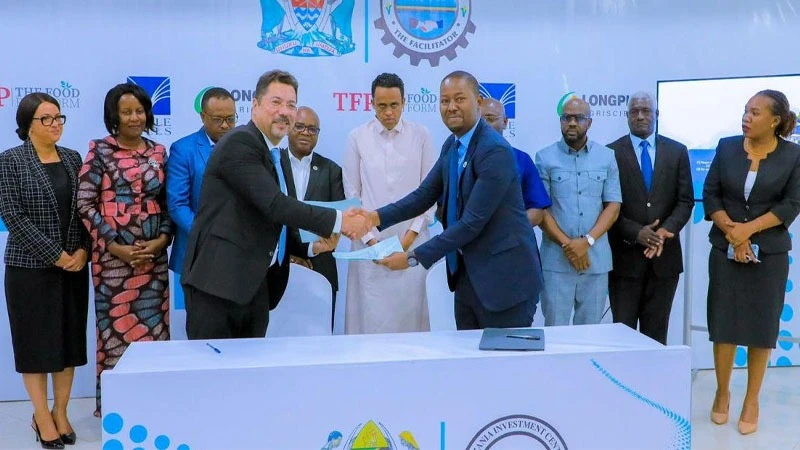 Tanzania Investment Center (TIC) Director General Gilead Teri (R) exchanging documents with the investor from Food platform company, Ibrahim Qammar shortly after signing the agreement for the development of Mkulazi agriculture in Morogoro region.