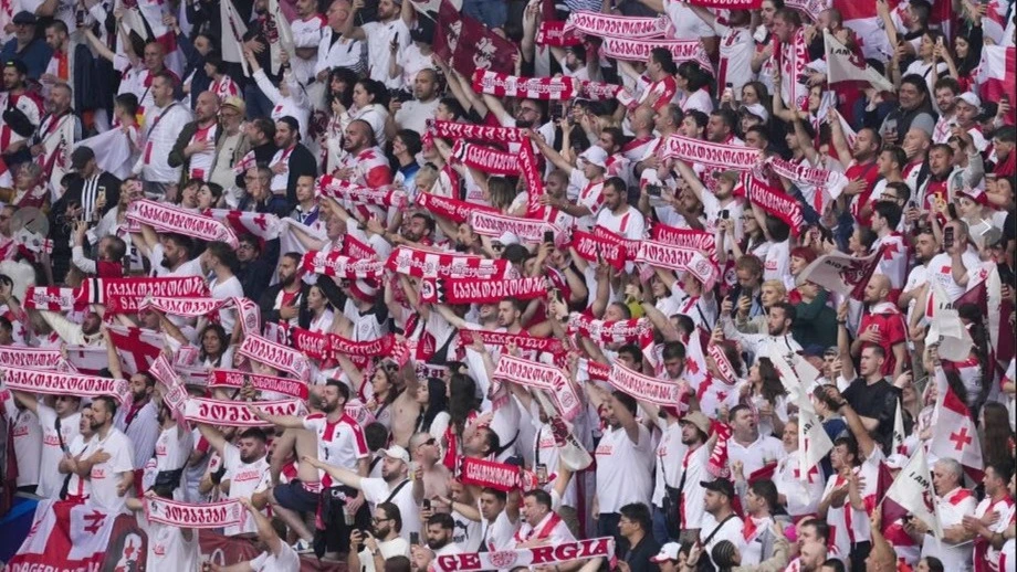 Georgia fans hold scarves during the national anthems ahead of a Group F match against Turkey at the Euro 2024 soccer tournament in Dortmund, Germany, Tuesday, June 18, 2024.