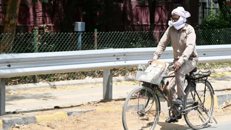  A delivery worker rides his bike on a hot summer day on May 20, 2024 in Gurugram, India 
