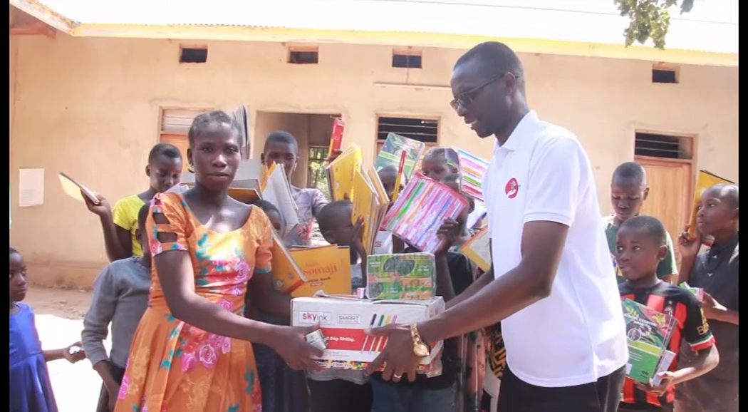 Manyango Nchimbi (R), an engineer, pictured earlier this week presenting an assortment of items to Lucia Paul, supervisor of 100 needy children from Nyamilangano and Iboja wards in Ushetu, Kahama District, earlier this week.