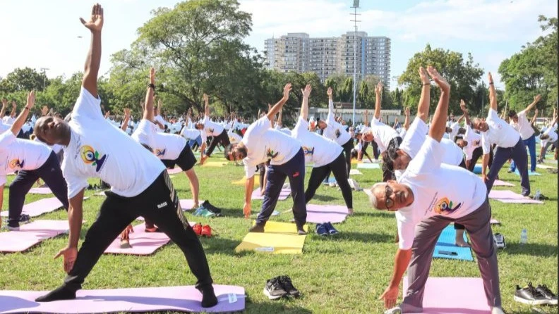 Gerson  Msigwa, Permanent Secretary in the Ministry of Culture, Arts and Sports (1st L),  and Manoj Verma, Charge d’Affaires at the High Commission of India  (1st R) and other people practice yoga exercises at the Dar es Salaam Gymkhana.