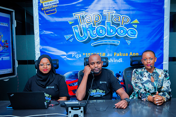 Silas Matoi (center), Head of Alternative Digital Channels at Exim Bank Tanzania, speaking with one of the 10 winners of the second draw of the Tap Tap Utoboe campaign aimed at encouraging the bank's customers to use mobile phones and the internet for pay