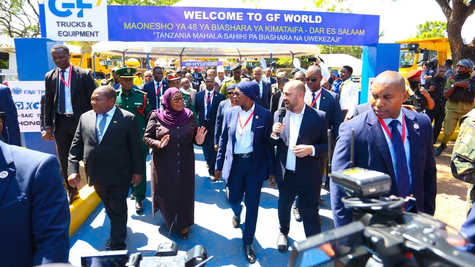 
President Samia Suluhu Hassan shares a word with Imrani Karmali, executive director of vehicle assembling firm during the president's visit to the 48th DITF on Wednesday. Looking on (left) is Filipe Nyusi, Mozambican President.