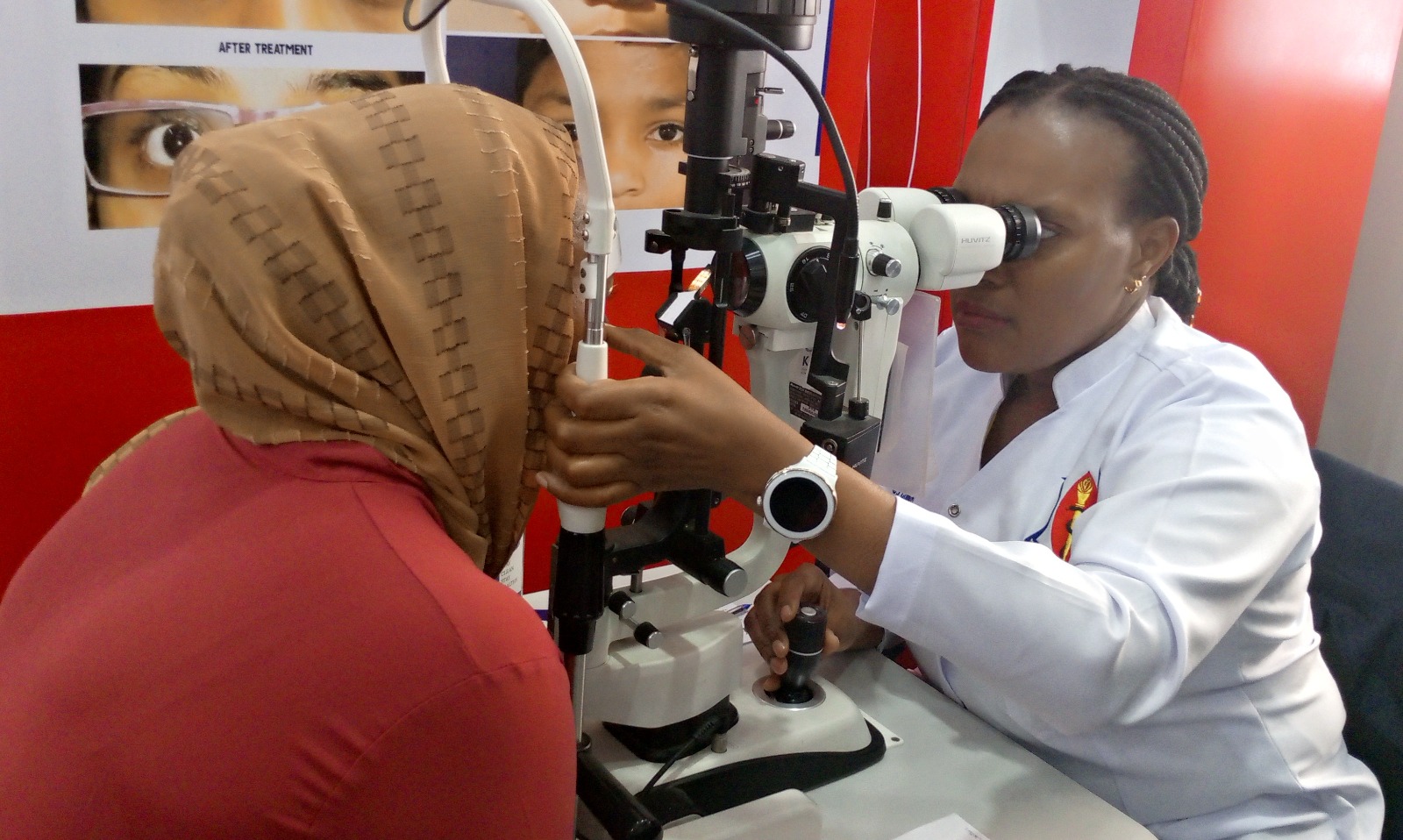 Dr Neema Moshi (R), an eye care specialist with Muhimbili National Hospital, examines a visitor at the hospital’s pavilion at the ongoing 48th edition of the Dar es Salaam International Trade Fair yesterday