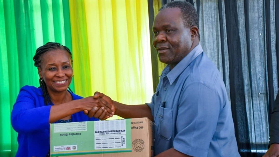 
Shangwe Twamala, the Ag DAS of the Coastal Region (R), receiving textbooks from Gertrude Mapunda, the representative of the British Embassy.