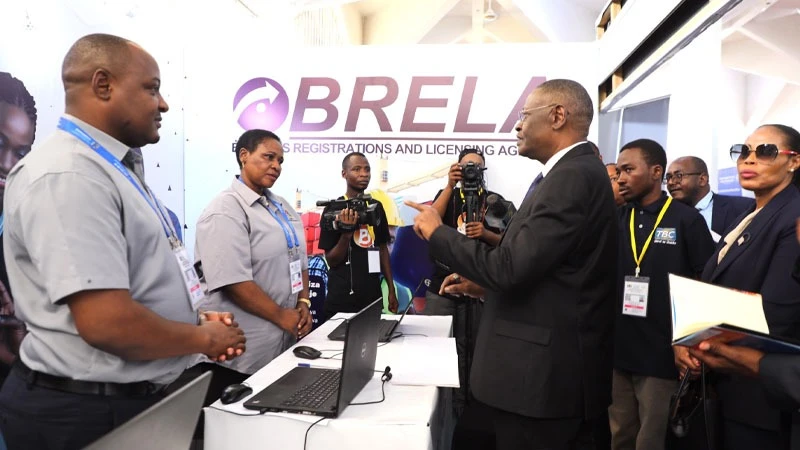 Chief Justice of Tanzania, Prof. Ibrahim Juma (with black suit) speaks to the Business Registration and Licensing Agency (BRELA) employees during his visit at the agency’s pavilion at the international trade fair that is going in Dar es Salaam.