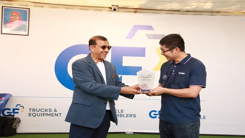 GF trucks & Equipment’s board chairman, Mehboob Karmal (L) presenting a gift to XCMG East African director, Zhang Wenyang after signing an agreement to supply the market with the company's machinery brands at an event held yesterday at the DITF grounds 