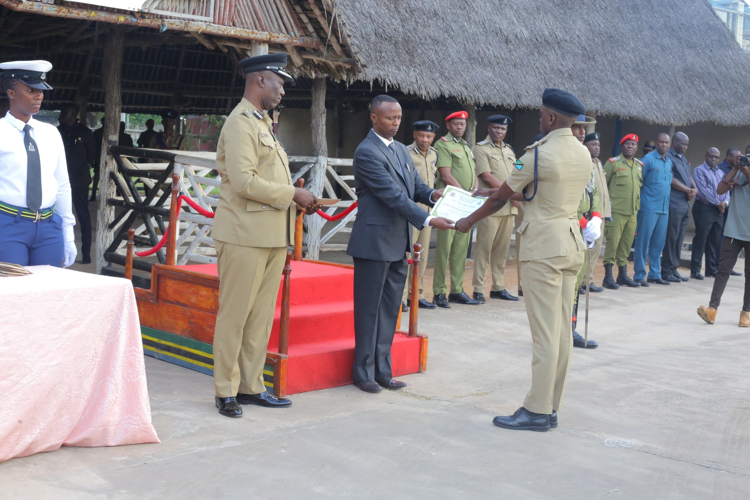  Director of Criminal Investigations Commissioner of Police Ramadhani Kingai presents a certificate to one of 13 police officers awarded for outstanding service. This was at a prize-giving ceremony held in Dar es Salaam yesterday. 