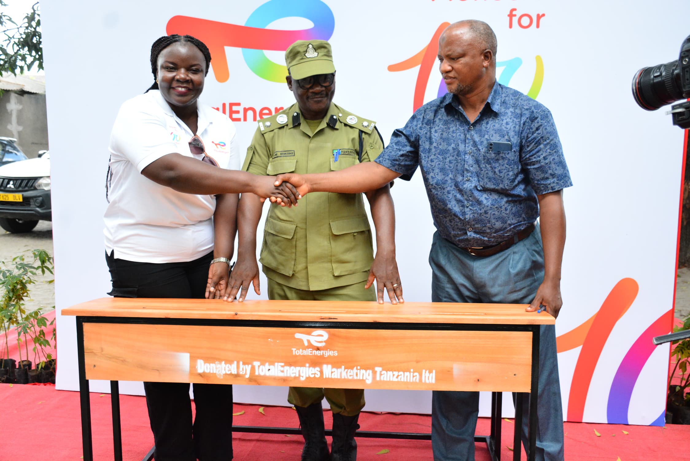 TotalEnergies Legal Affairs and Relations director Getrude Mpangile (L) pictured in Dar es Salaam yesterday symbolically presenting 70 desks to Mohamed Athumani, headteacher of the city’s Makuburi Primary School. 