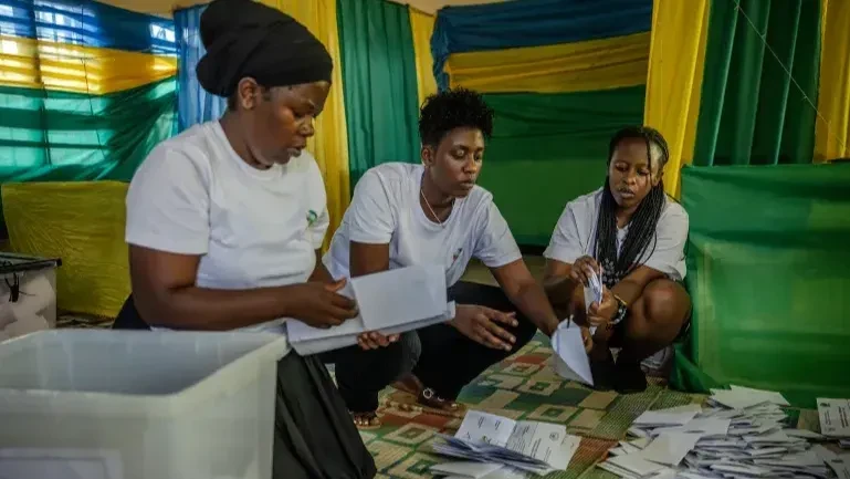 Rwanda National Electoral Commission (NEC) officials arranges marked ballots following the closing of the polls during the 2024 Rwandan general elections at a polling station in Kigali