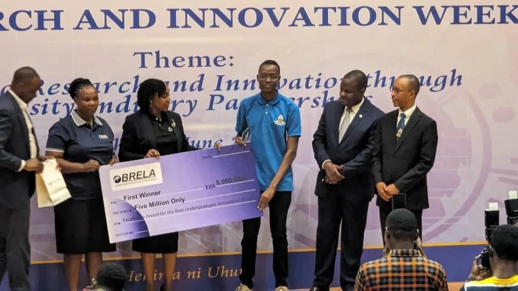 Masunga Maganga (3rd – R), a fourth-year student at the UDSM, receiving a dummy cheque worth 5m/- from a BRELA officials.
