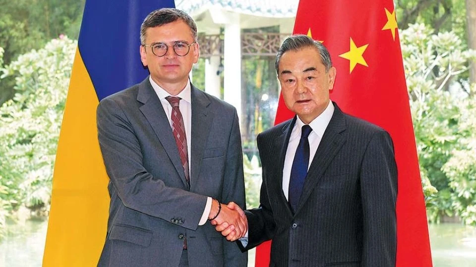 Foreign Minister Wang Yi (right) shakes hands with Ukrainian Foreign Minister Dmytro Kuleba on Wednesday during their meeting in Guangzhou, Guangdong province. 