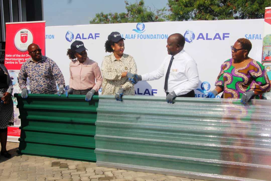 Muhimbili Orthopedic Institute (MOI) Acting Managing Director Dr Antony Assey (2nd R) receives a donation of iron sheets worth 35m/-’- from the ALAF Limited Tanzania External Affairs Officer Theresia Mmasy to assist in renovation 