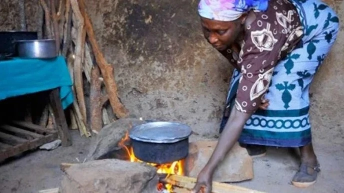 Rural womon uses firewood in cooking.