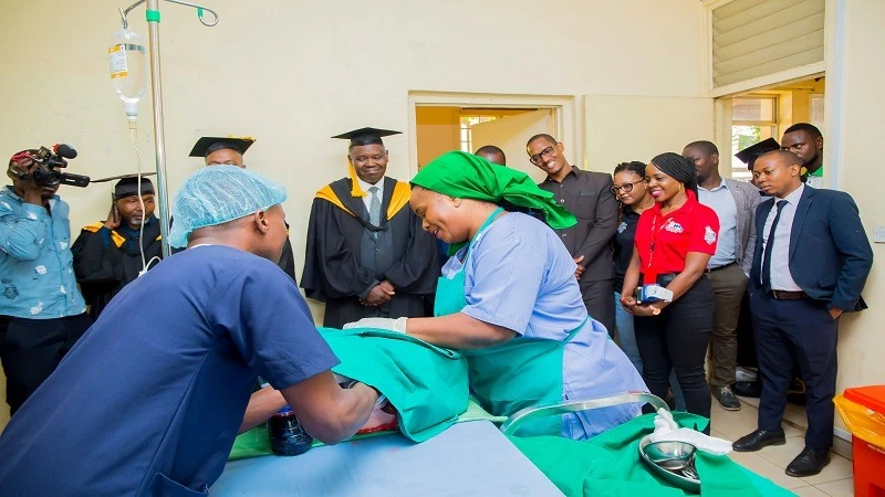 NBC’s Morogoro branch manager, Deusdedit Mashalla (C) witnesses some of the midwifery diploma graduates at the Morogoro College of Health and Allied Sciences (MCOHAS) demonstrating practical skills in caring for mothers and babies during childbirth.