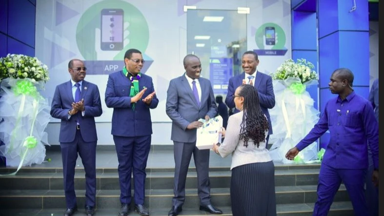 KCB Bank’s Board Director, Jacqueline Woiso hands over gift to the Deputy Prime Minister and Minister for Energy, Dr Doto Biteko after unveiling the new KCB Bank branch in Geita District, Geita Region. 