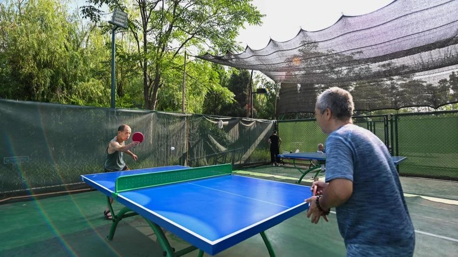 People play table tennis at a city park in north China's Tianjin Municipality, Aug. 8, 2024. 