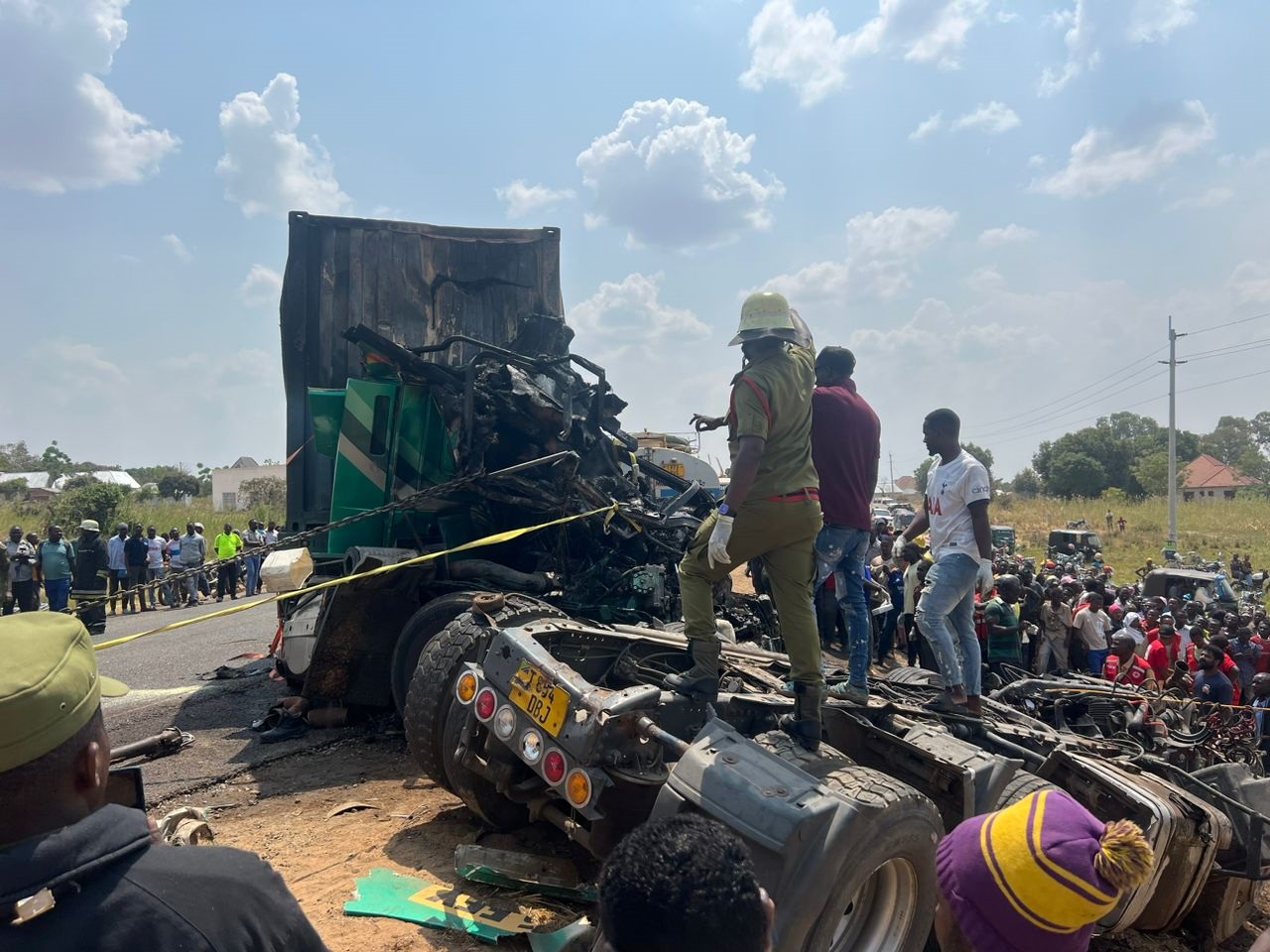 Residents join Fire and Rescue Force yesterday in efforts to retrieve three bodies of people killed in a crash involving two vehicles. 